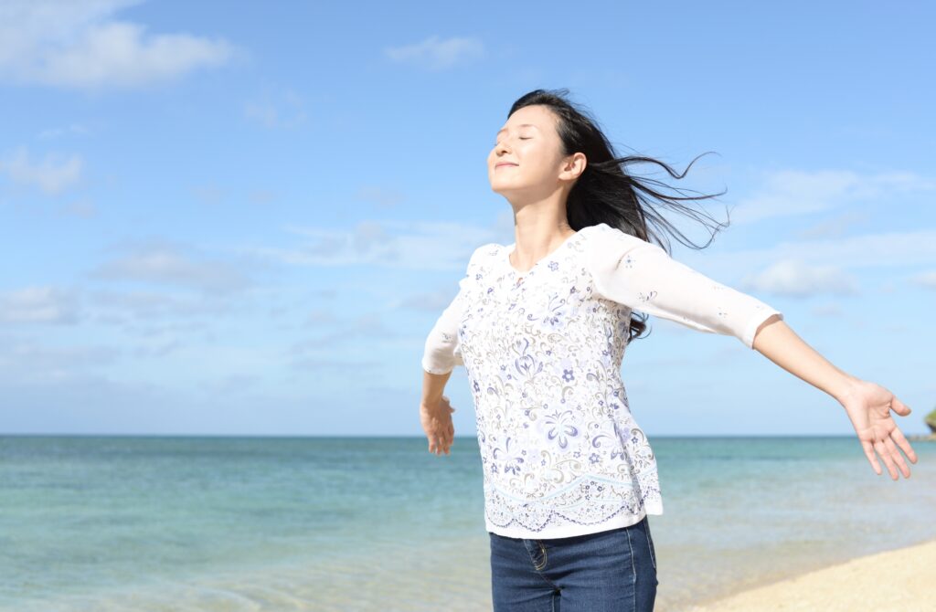 海を背景に風を浴びる女性