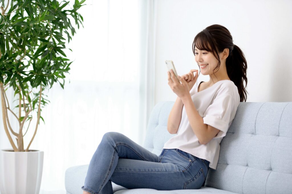 ソファでスマホを見る女性