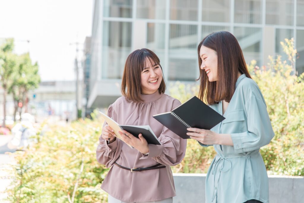 ビルの前でノートを見ながら勉強する大学生