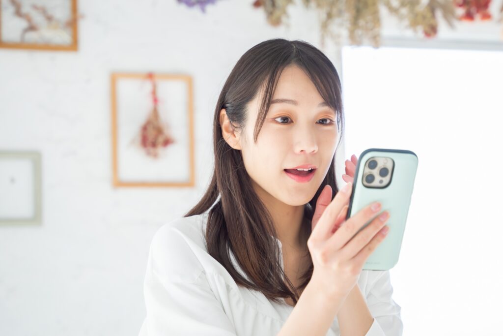スマホを見て驚く女性