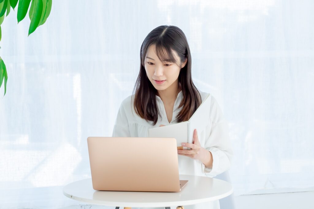 ノートパソコンを開き仕事する女性