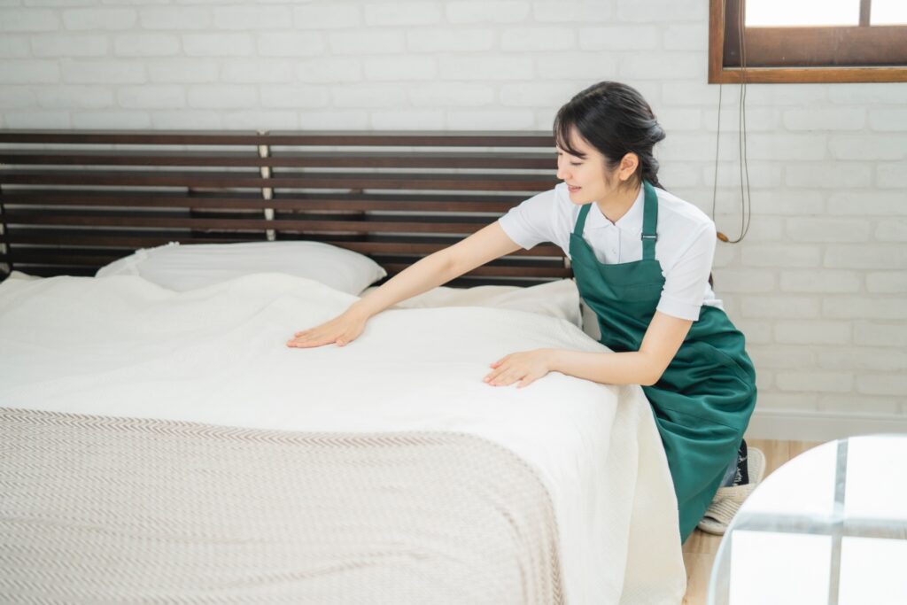 シーツを整える女性