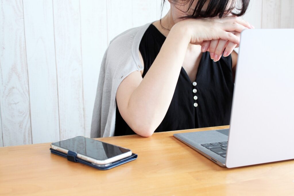 PCの前でうなだれる女性