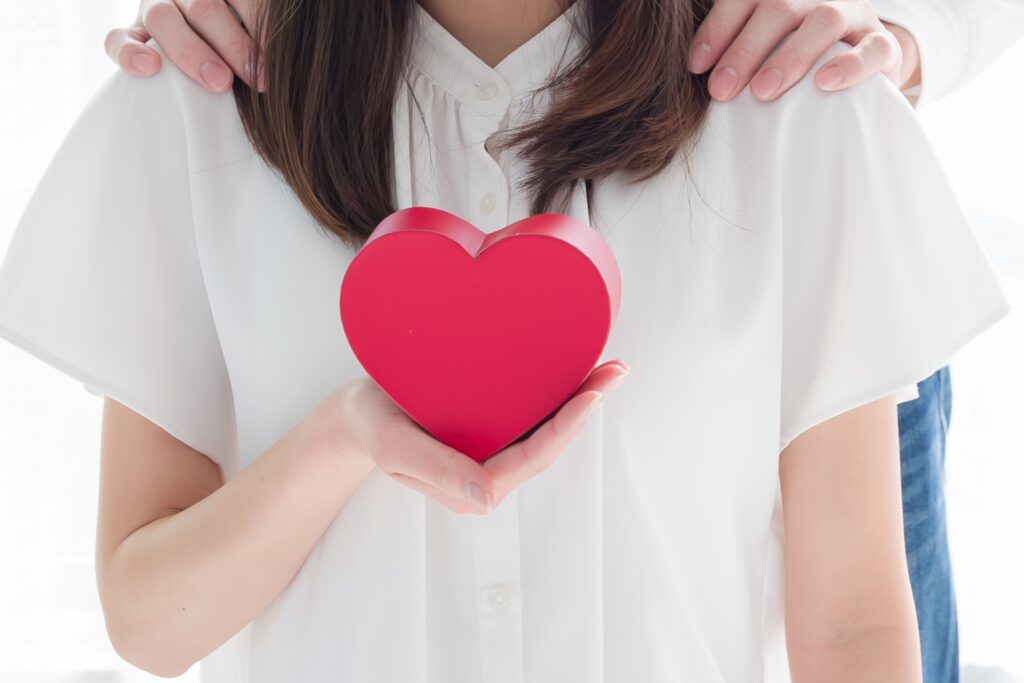 ハートを持つ女性と肩に手を置く男性