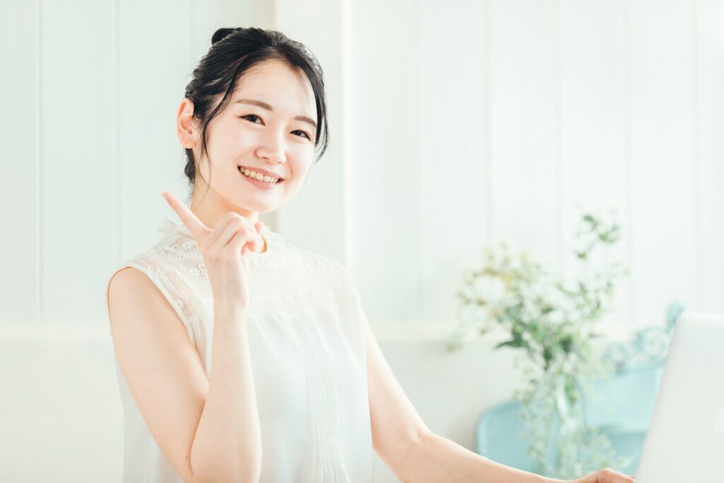 指を立てて案内する女性