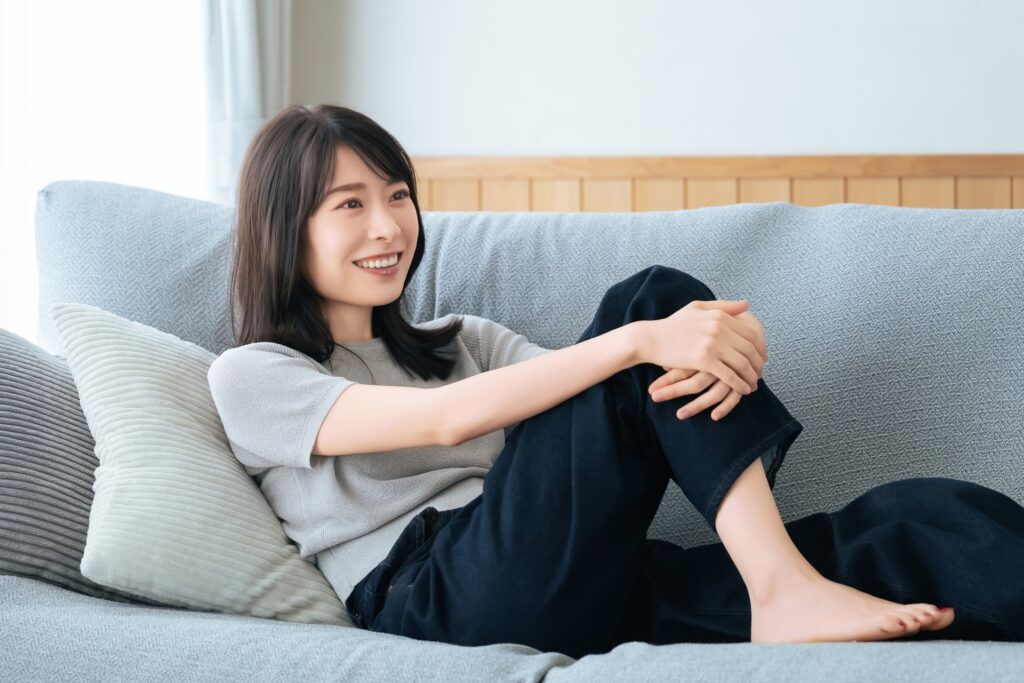 リビングのソファに座る笑顔の女性