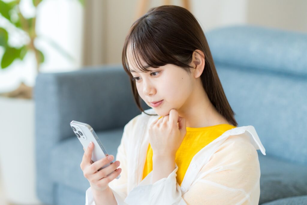 スマホを見て考える女性