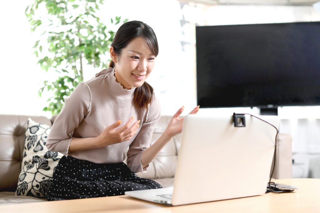 オンラインで話すノートパソコンと笑顔の若い女性