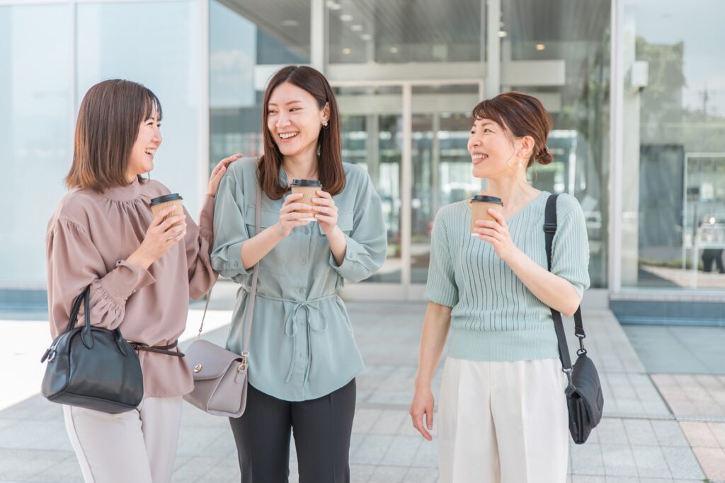 コーヒーを持ちながら話す女性