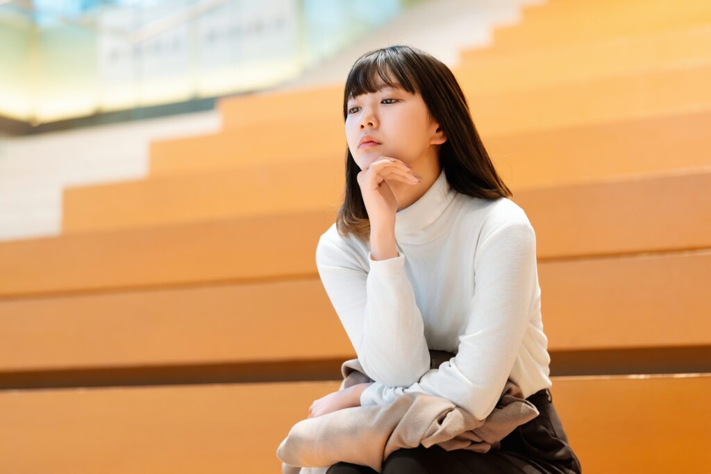 考えごとをする若い女性・ビジネスウーマン