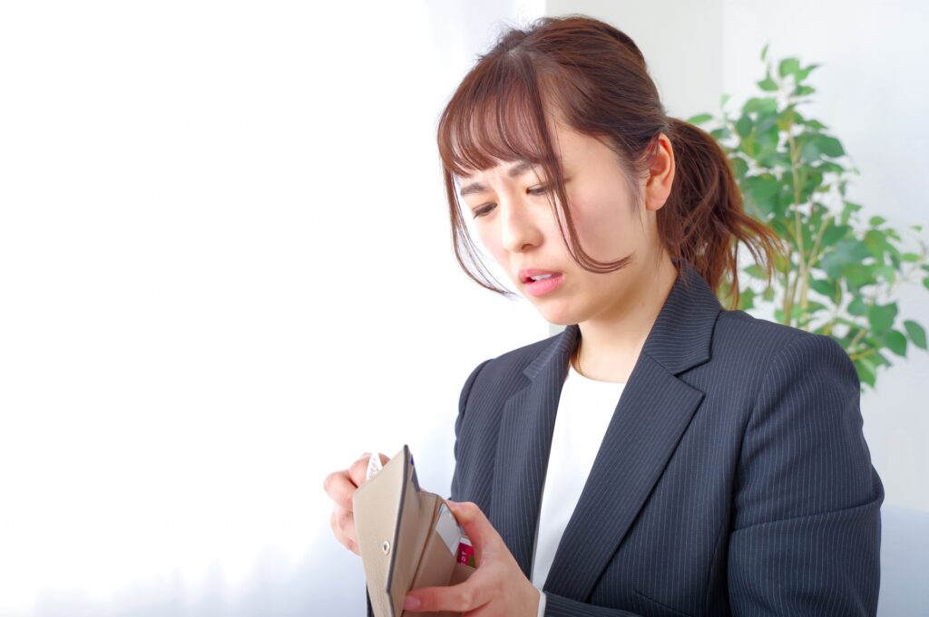 お金がないアピールをするスーツ姿の女性
