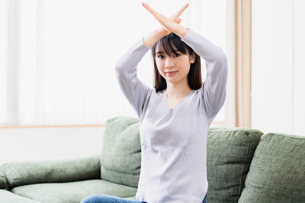 NGのジェスチャーをする女性