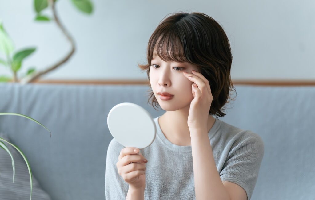 手鏡で身だしなみをチェックする女性