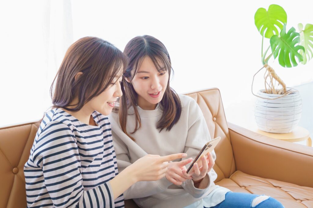スマートフォンを指差す女性