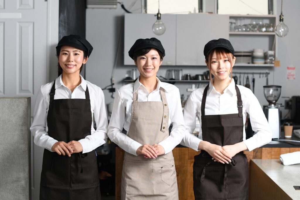 飲食店で働くエプロン姿の複数の女性達