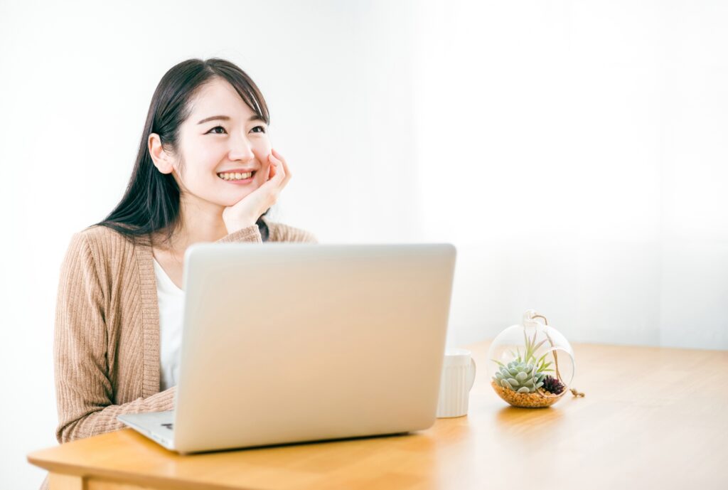 家でノートパソコンを使って副業をする女性