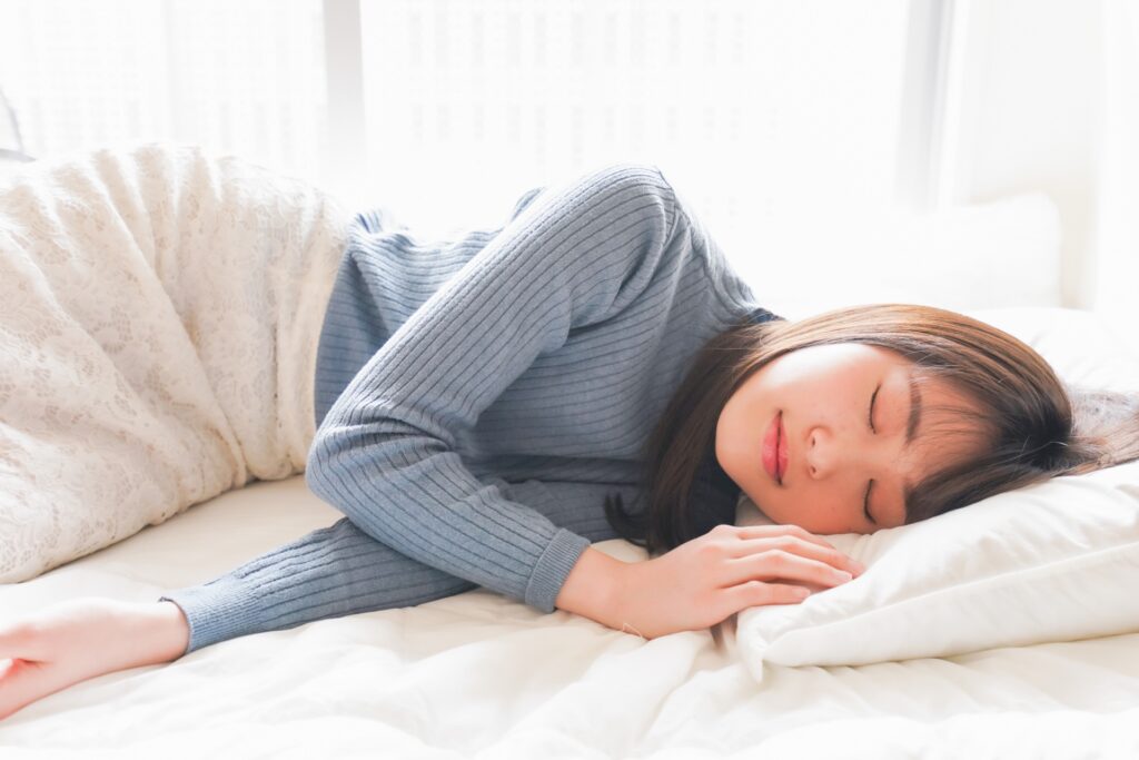 布団に入って睡眠を取る若い女性