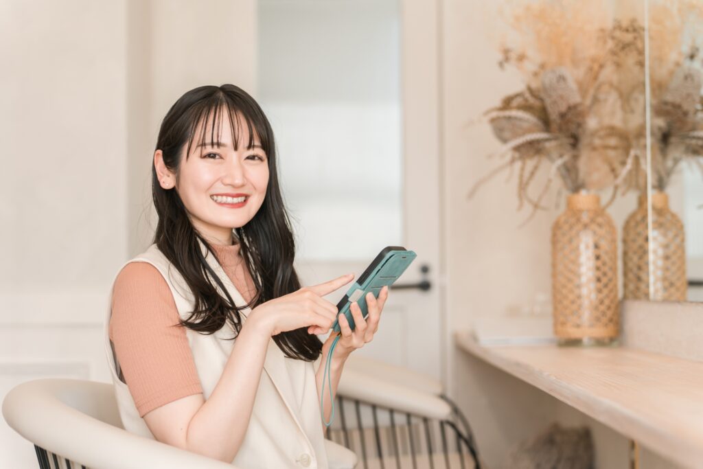美容室・ヘアサロンでスマホを使う女性