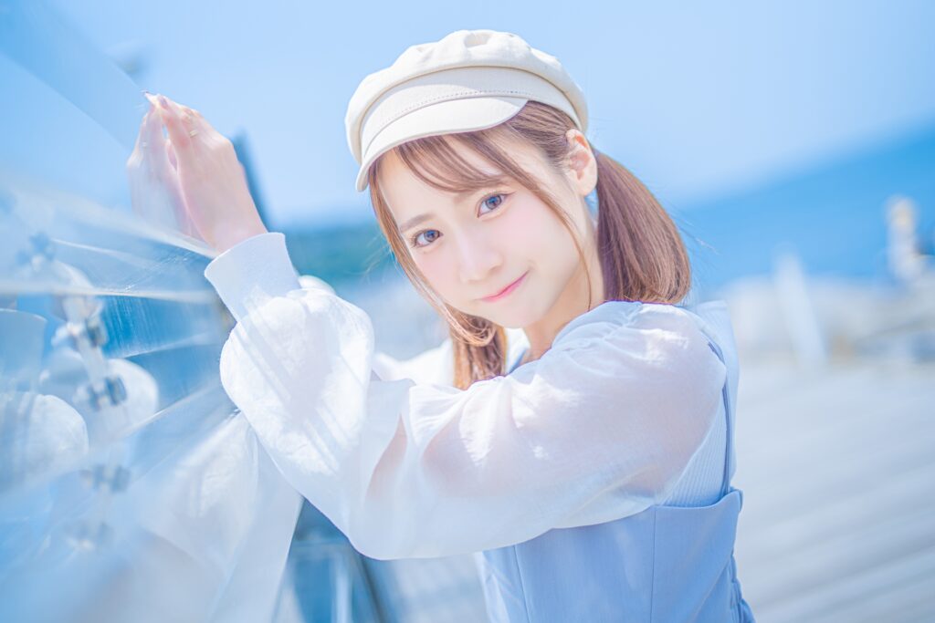 海をバックにこちらを見つめる女性