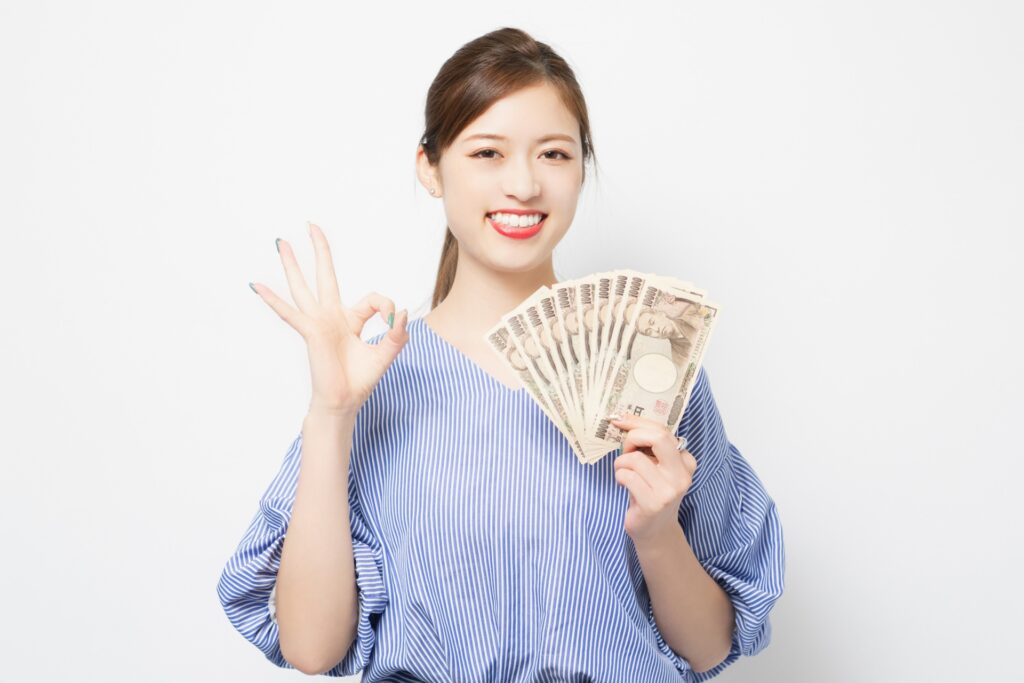 お金を手に持つ若い女性